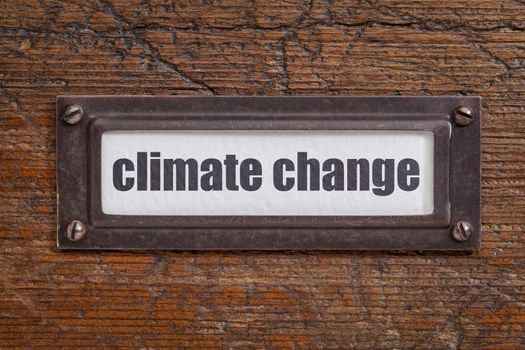 climate change  - file cabinet label, bronze holder against grunge and scratched wood