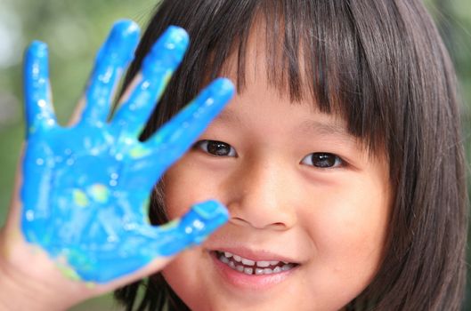 child painting and playing with finger painting colours (chinese child)