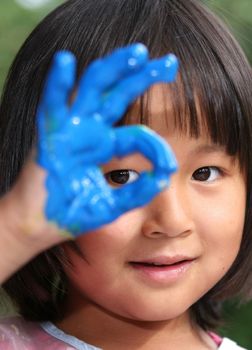 child painting and playing with finger painting colours (chinese child)