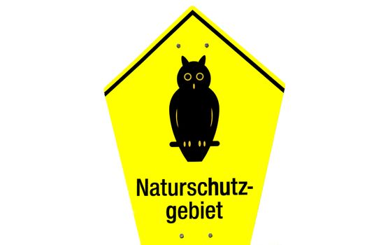 Black owl and text naturschutz gebiet on yellow birdhouse shape