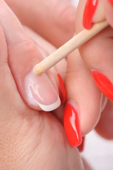 beauty salon, manicure applying, cleaning the cuticles with wooden stick