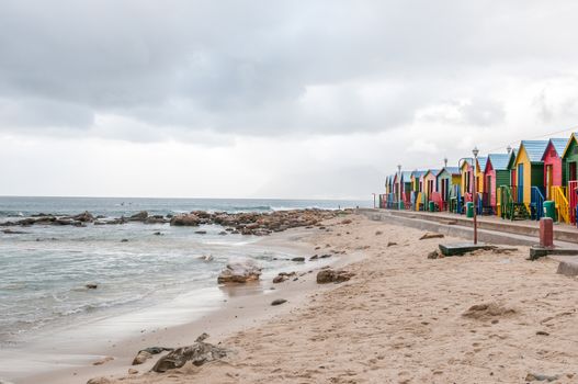 Multi-coloured beach huts at St. James beach on a rainy morning
