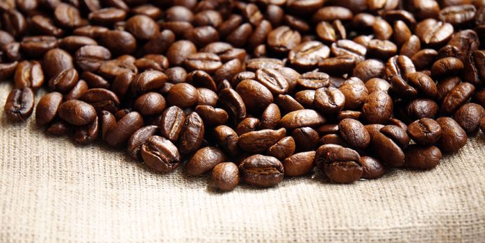 Background from coffee beans on fabric closeup                               