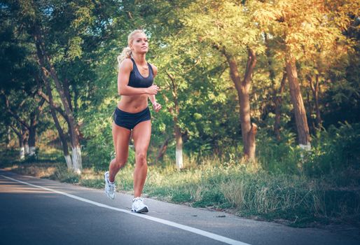 young woman jogging in the park in summer