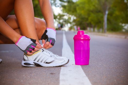 Woman runner tying sport shoes