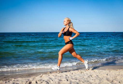 Running woman. Female runner jogging during outdoor workout on beach