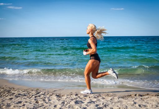 Running woman. Female runner jogging during outdoor workout on beach