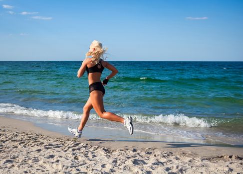 Running woman. Female runner jogging during outdoor workout on beach