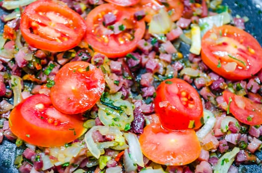 Tomatoes with bacon, onions and spices. Basis for a tomato sauce.