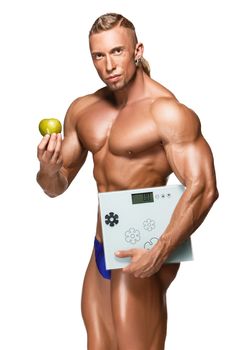 Shaped and healthy body man holding a fresh apple and scales, isolated on white background