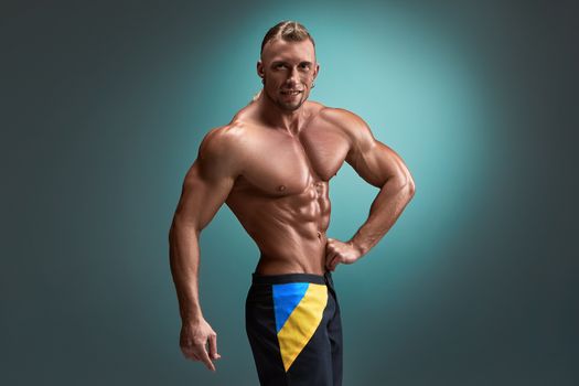 torso of attractive male body builder on blue background.