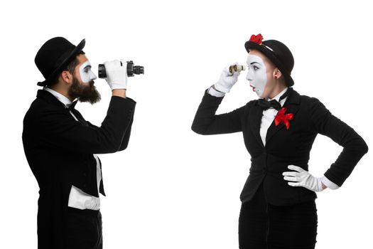 Two memes as business people looking at each other through binoculars isolated on white background. concept of suspicion and mistrust