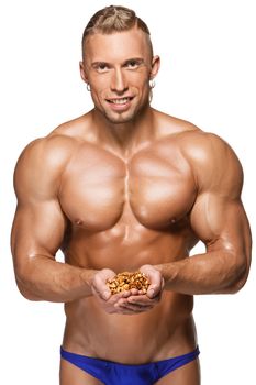 Shaped and healthy body man holding a walnuts, isolated on white background