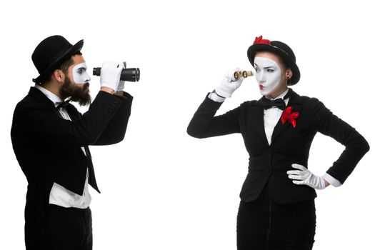 Two memes as business people looking at each other through binoculars isolated on white background. concept of suspicion and mistrust