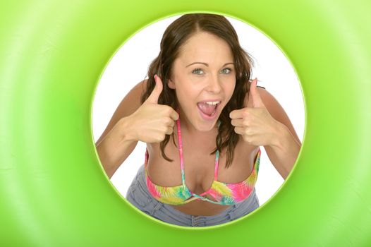 Attractive Young Woman Looking Through a Green Rubber Ring Giving Thumbs Up Sign