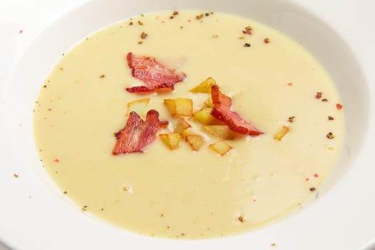 soup-puree with bacon and fried potatoes. On white background