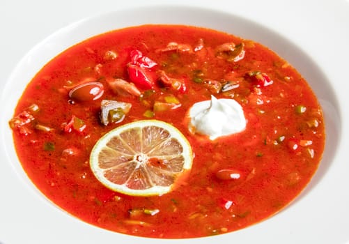 Red vegetable soup with beans and lemon. On white background