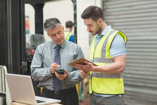 Portrait of manual workers scanning package in the warehouse