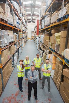 Team standing behind their boss in warehouse