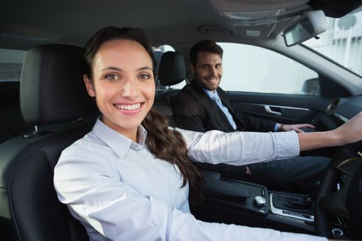 Business team smiling at the camera in the car