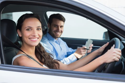 Young woman getting a driving lesson in the car