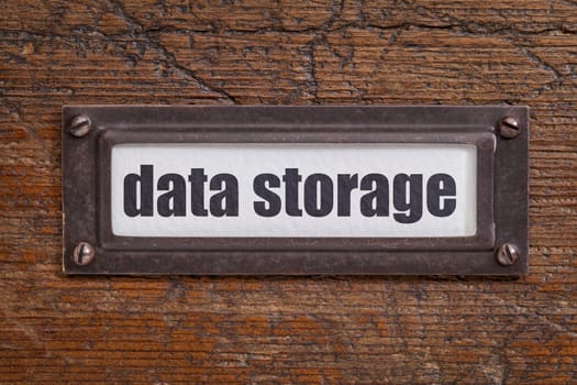 data storage  - file cabinet label, bronze holder against grunge and scratched wood