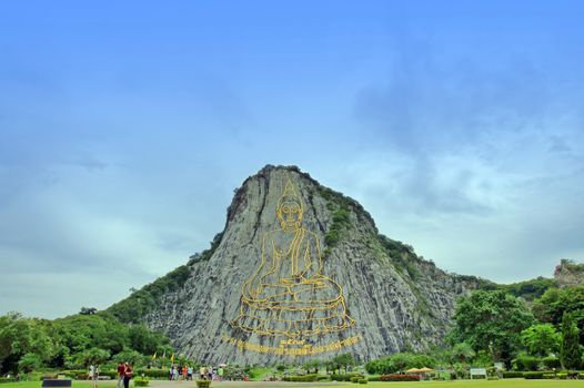 Touristic place in Thailand, Golden Buddha.Giant picture made of gold on the rock.