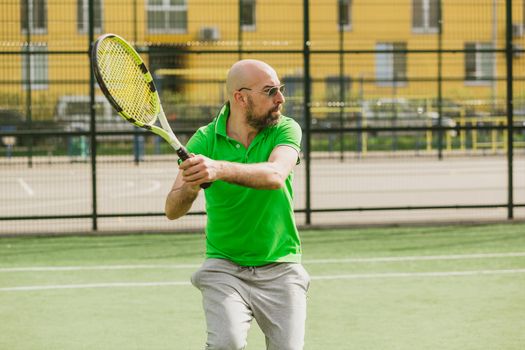 young man play tennis outdoor on tennis field at early morning