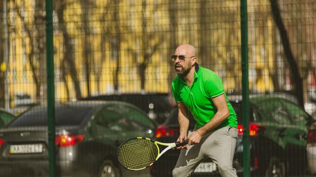 young man play tennis outdoor on tennis field at early morning