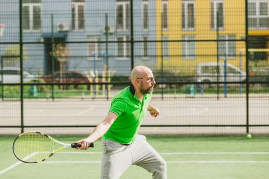 young man play tennis outdoor on tennis field at early morning