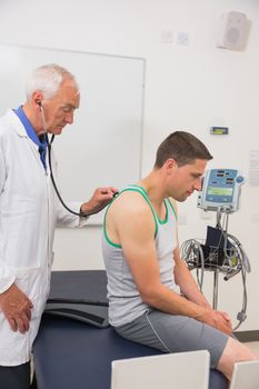 Doctor listening to patient with stethoscope at the medical centre
