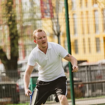 young man play tennis outdoor on tennis field at early morning