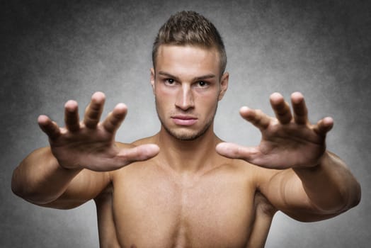 Athlete with a well trained body holds up his hands to defend