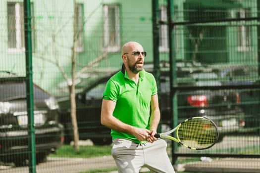 young man play tennis outdoor on tennis field at early morning