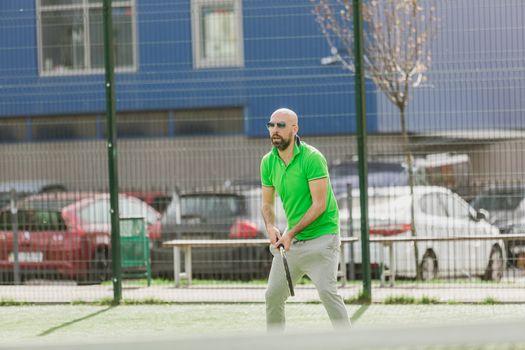 young man play tennis outdoor on tennis field at early morning