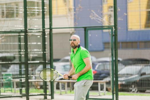 young man play tennis outdoor on tennis field at early morning