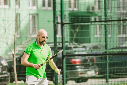 young man play tennis outdoor on tennis field at early morning