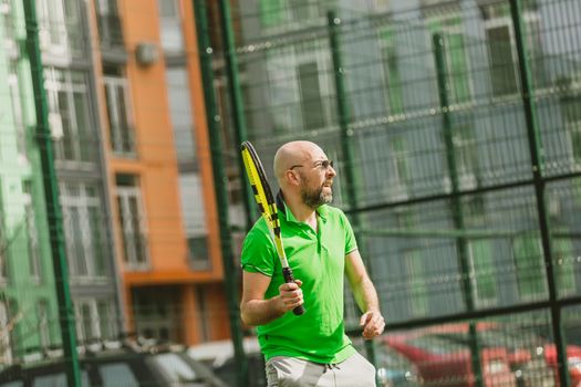 young man play tennis outdoor on tennis field at early morning