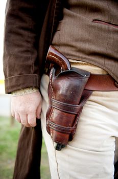 Image close up of a gun in a holster strapped to a cowboy