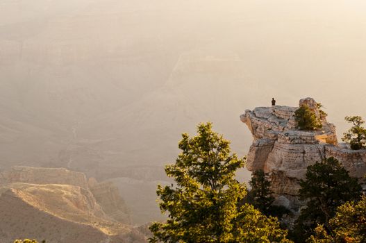 Image of a man standing on a cliff overlooking the Grand Canyon