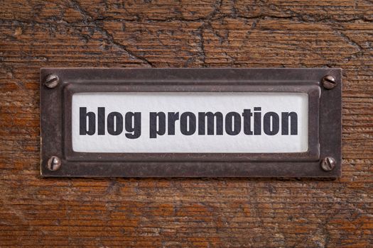 blog promotion- file cabinet label, bronze holder against grunge and scratched wood