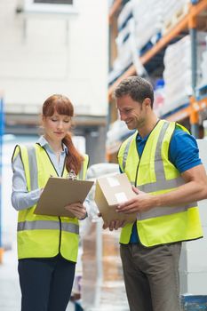 Smiling warehouse manager and delivery man in warehouse