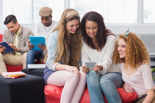 Fashion students looking at smartphone at the college