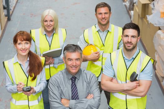 Team standing behind their boss in warehouse