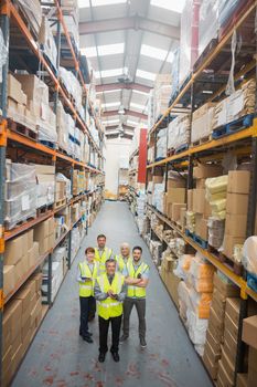 Warehouse team smiling at camera in warehouse