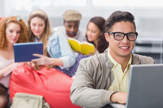 Fashion student using his laptop at the college