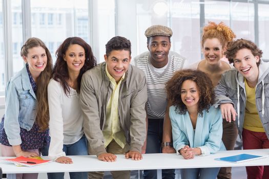 Fashion students smiling at camera together at the college