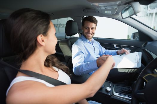 Young woman getting a driving lesson in the car