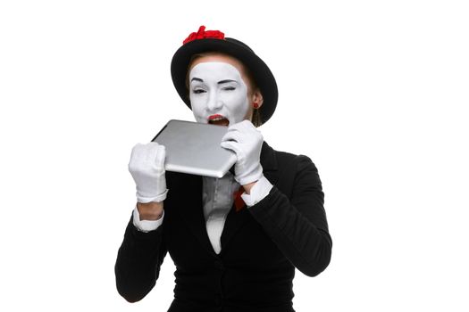 business woman in the image mime holding tablet PC and trying to tooth isolated on white background