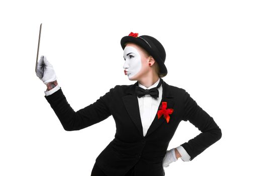 business woman in the image mime holding tablet PC and  looking at a tablet PC as a mirror  isolated on white background. concept of concept of narcissism at work